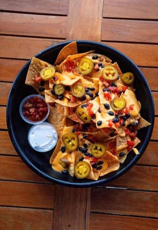 Loaded Nachos with jalapeño slices and dips